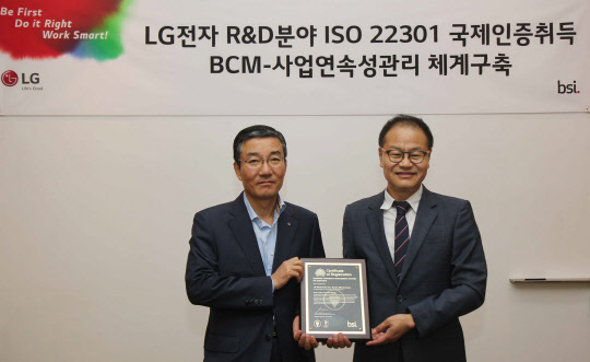 LG전자 가산R&D(연구개발)캠퍼스가 생활가전 연구개발 분야 최초로 국제인증기관인 영국표준협회(BSI)로부터 사업연속성관리체계 인증을 획득했다. 이감규 LG전자 부사장(왼쪽)과 이종호 BSI코리아 대표이사가 기념 촬영을 하고 있다. <LG전자 제공>
